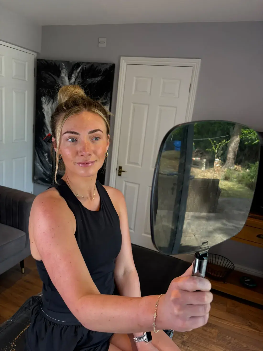 A model admiring her finished brows in the mirror after a Beauty Within training session